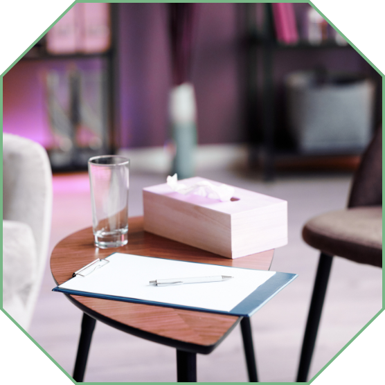 A therapy room, with a glass of water and box of tissues on the table.